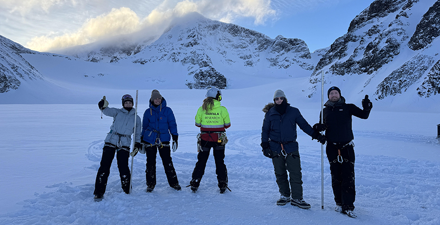 Bild på fyra lärare som gjorde resan. De står utomhus med vinterlandskap och berg bakom. 